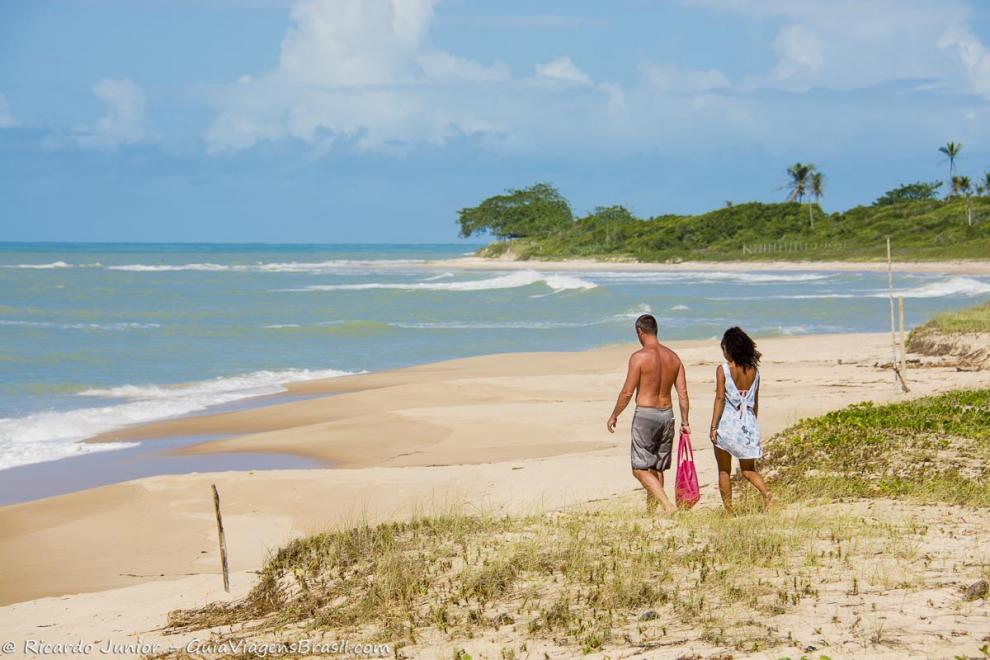 Imagem de um casal caminhando nas areias da Praia Ponta de Itaquena.